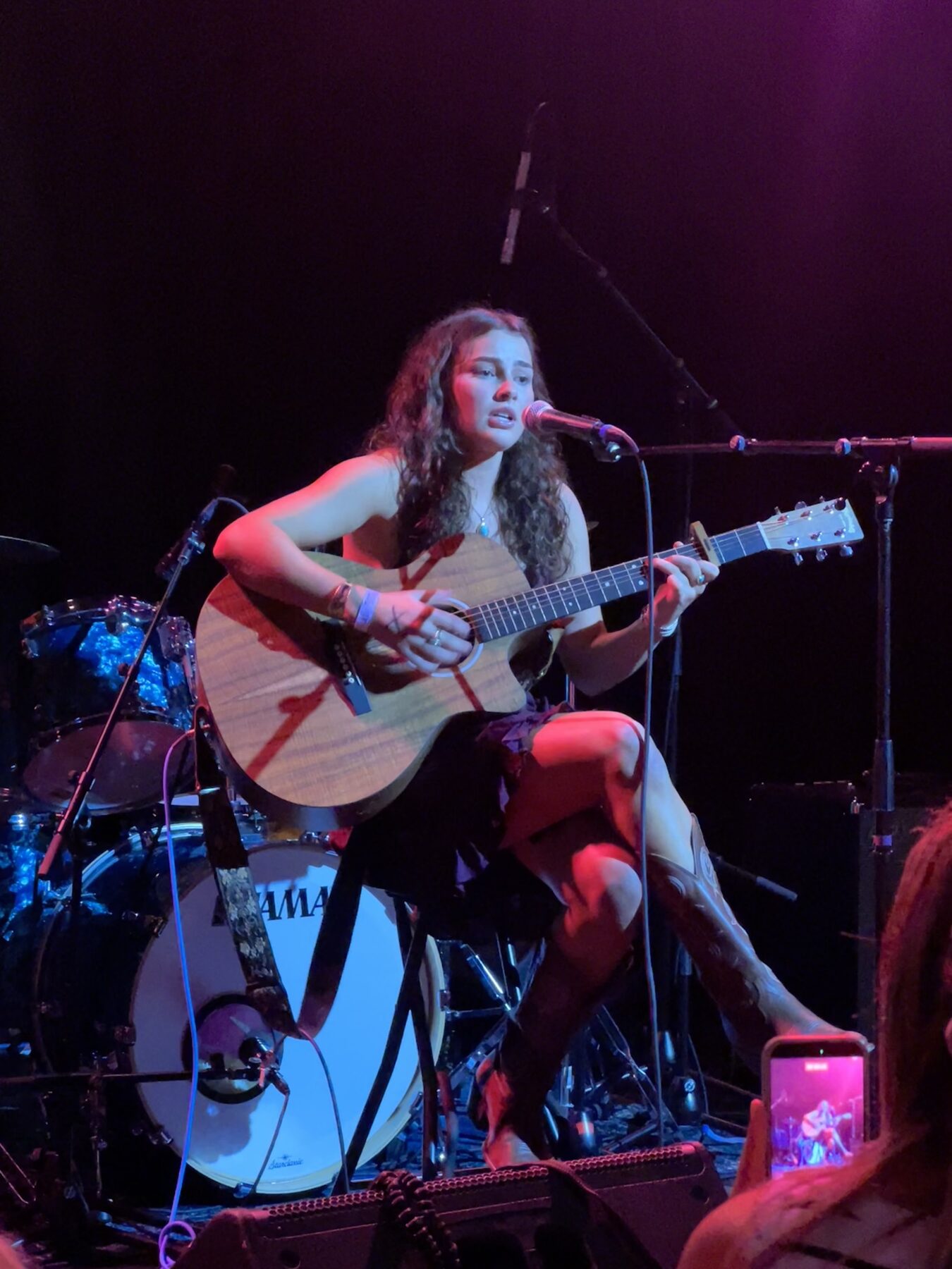 Kailey Jane playing acoustic guitar on a stool at Pearl Street Warehouse